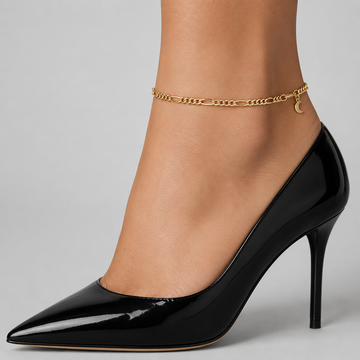 Gold figaro chain anklet - classic figaro links with a crescent moon charm, close-up on the ankle