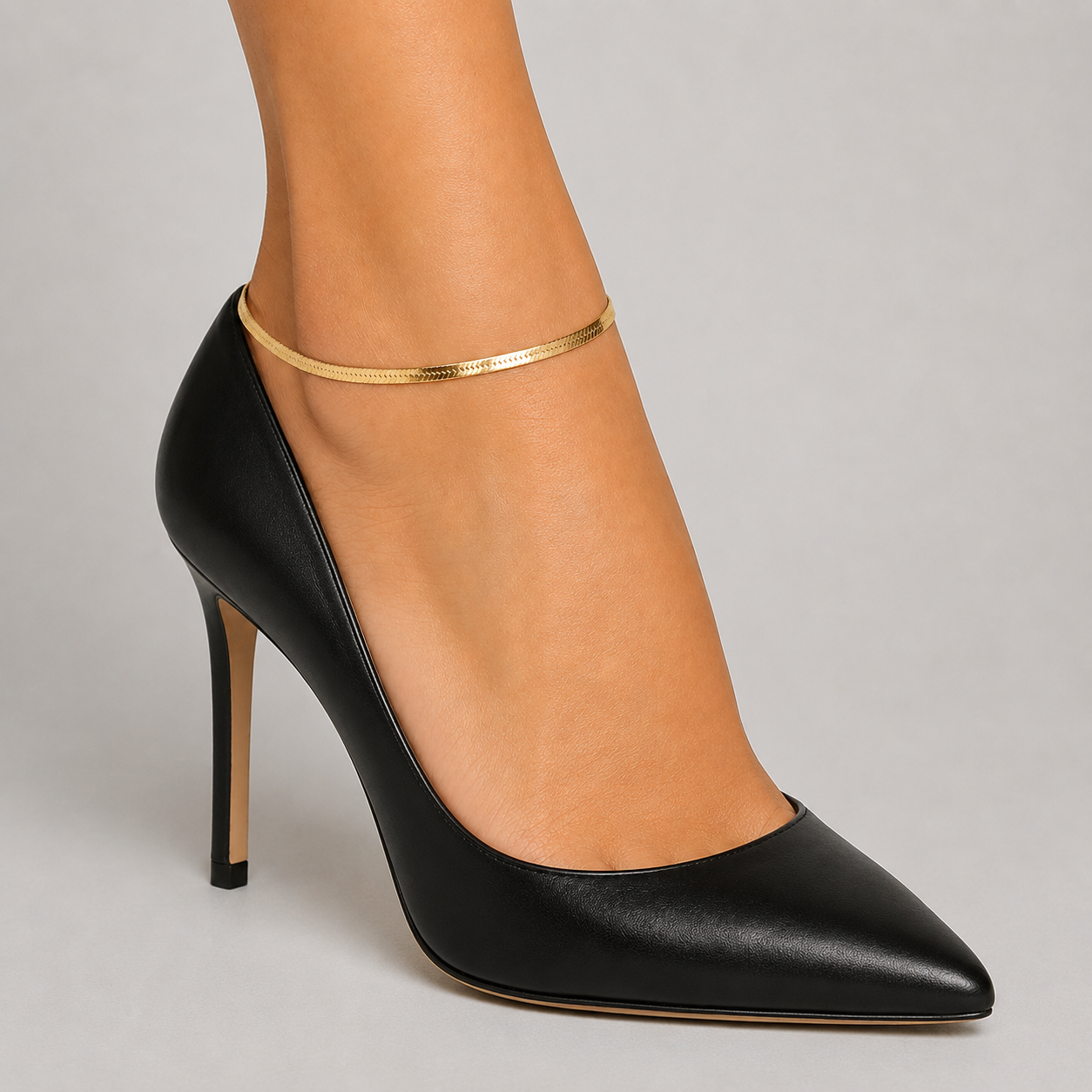 Minimalist gold herringbone ankle bracelet with black pointed heels - flat chain, side view