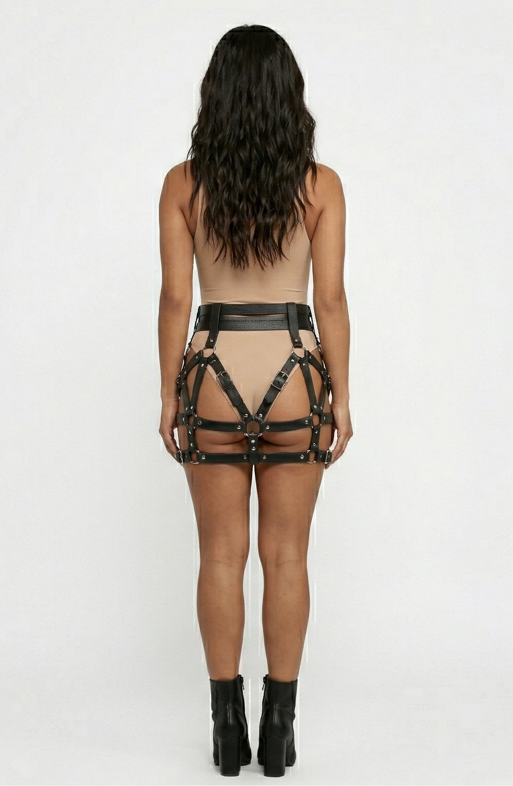 Black faux leather cage skirt showing rear waist band and crisscross straps, back view