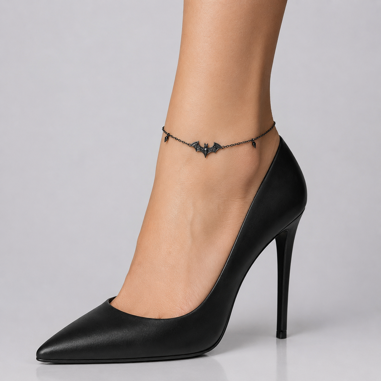 Bat anklet with a black bat charm styled with black heels - side view on the ankle