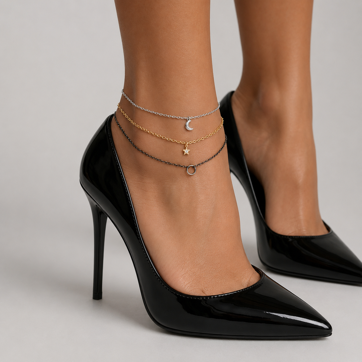 Mixed metal anklet styled with black stiletto heels - layered gold, silver and gunmetal chains, side view